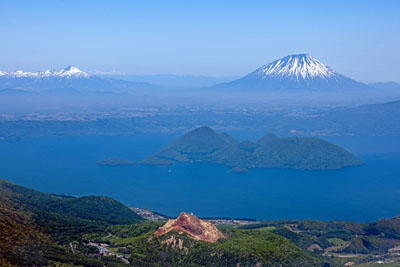 Vue sur le lac Tôya 洞爺湖 et les volcans environnants dont le Shôwa-shinzan 昭和新山 tout en bas de l’image © Tsukioka Yôichi 月岡陽一www.tsukioka-world.com